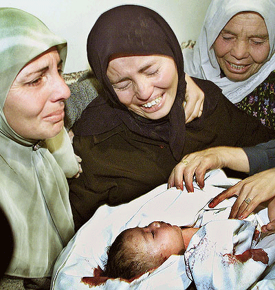 Rima Tmeizi cries, holding the body of her murdered three-month-old son prior to his burial